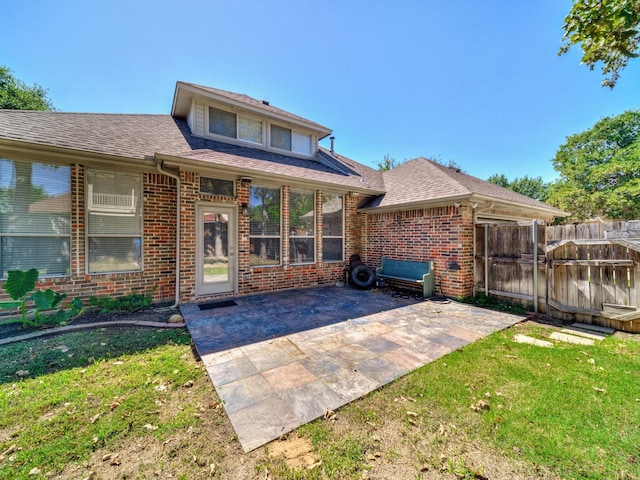back of property with a patio area, brick siding, and a shingled roof