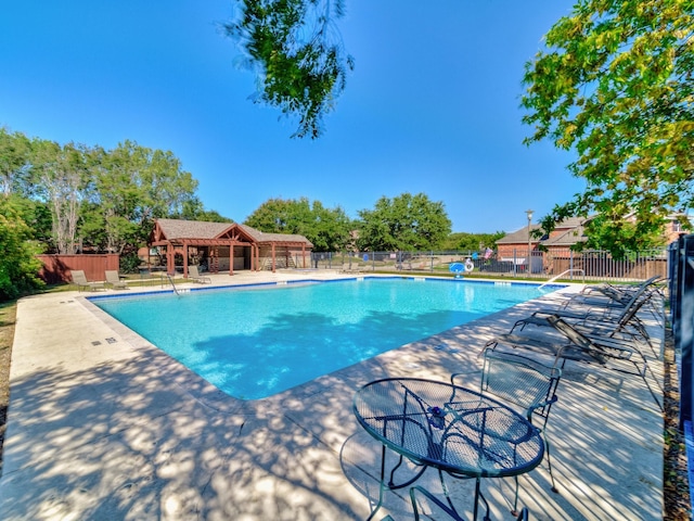 community pool featuring fence and a patio area