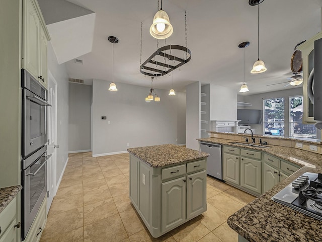 kitchen with stainless steel appliances, a sink, a center island, a ceiling fan, and stone counters