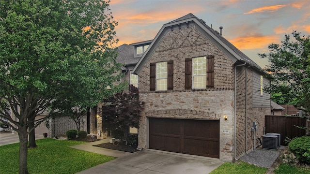 8205 Saint Clair Dr, Mckinney, TX 75071 - view of front of house with an attached garage, driveway, stone siding, central AC, and brick siding