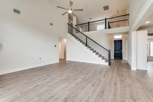 6725 Palmdale Dr, Fort Worth, TX 76123 - unfurnished living room featuring stairs, a towering ceiling, a ceiling fan, light wood-type flooring, and baseboards