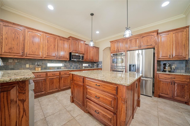 1020 High Meadow Dr, Mount Vernon, TX 75457 - kitchen featuring appliances with stainless steel finishes, a kitchen island, brown cabinets, arched walkways, and tasteful backsplash