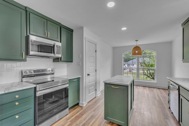 15630 Brittain Ct, Lindale, TX 75771 - kitchen with green cabinetry, appliances with stainless steel finishes, light wood-style floors, light stone countertops, and recessed lighting