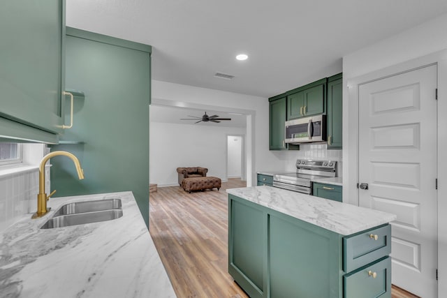 15630 Brittain Ct, Lindale, TX 75771 - kitchen with green cabinetry, stainless steel appliances, a sink, backsplash, and ceiling fan