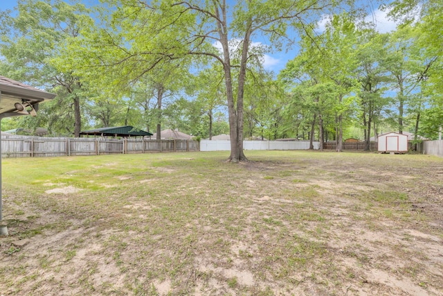 15630 Brittain Ct, Lindale, TX 75771 - fenced backyard featuring a storage unit, a detached carport, and an outdoor structure