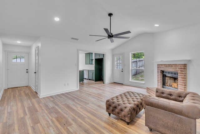 15630 Brittain Ct, Lindale, TX 75771 - living room with a ceiling fan, light wood finished floors, a brick fireplace, recessed lighting, and vaulted ceiling