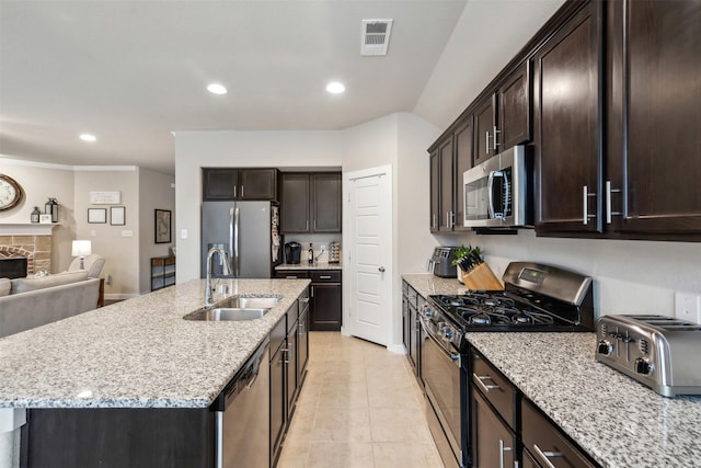 8332 Trickham Bnd, Fort Worth, TX 76131 - kitchen with stainless steel appliances, a sink, dark brown cabinetry, open floor plan, and light stone counters