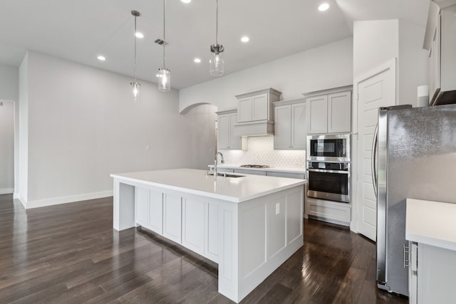 1108 Sandgate Dr, Forney, TX 75126 - kitchen featuring stainless steel appliances, a sink, a center island with sink, backsplash, and dark wood finished floors