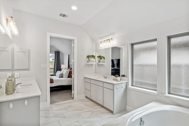 1108 Sandgate Dr, Forney, TX 75126 - ensuite bathroom with vaulted ceiling, two vanities, a garden tub, marble finish flooring, and baseboards