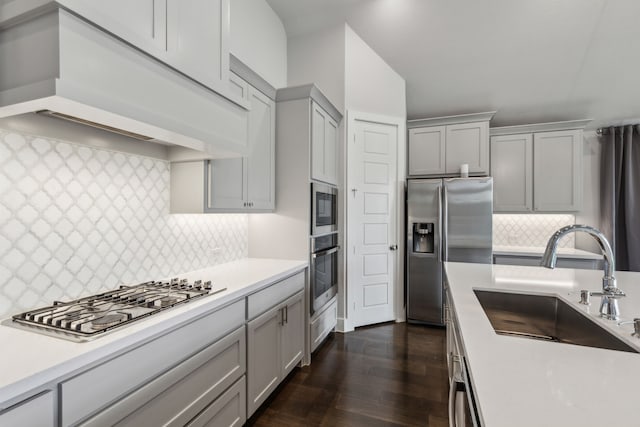 1108 Sandgate Dr, Forney, TX 75126 - kitchen with appliances with stainless steel finishes, gray cabinetry, a sink, custom range hood, and backsplash