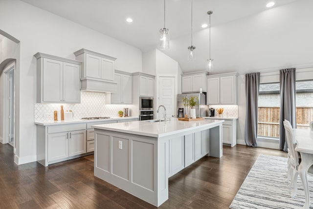 1108 Sandgate Dr, Forney, TX 75126 - kitchen with stainless steel appliances, vaulted ceiling, light countertops, backsplash, and a kitchen island with sink