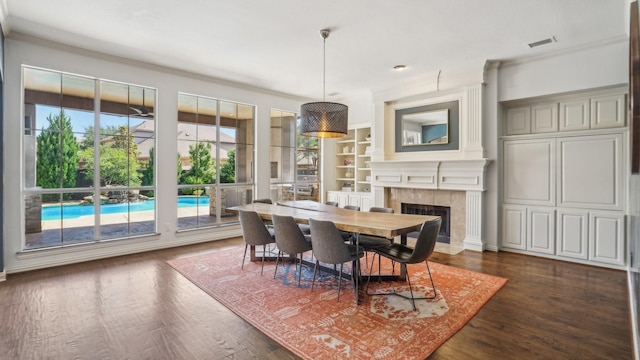 2026 Spindletop Trl, Frisco, TX 75033 - dining space with a premium fireplace, dark wood-type flooring, ornamental molding, and built in shelves