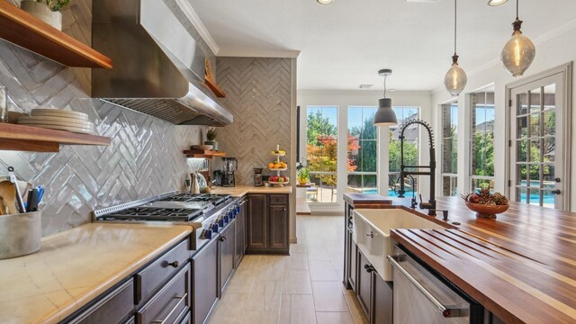 2026 Spindletop Trl, Frisco, TX 75033 - kitchen with open shelves, butcher block counters, wall chimney exhaust hood, appliances with stainless steel finishes, and backsplash