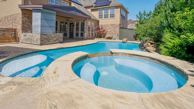 2026 Spindletop Trl, Frisco, TX 75033 - view of swimming pool with fence, a pool with connected hot tub, and a patio