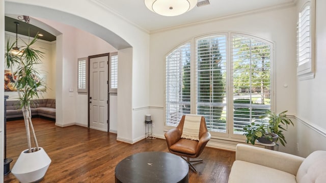 2026 Spindletop Trl, Frisco, TX 75033 - living area featuring wood finished floors, healthy amount of natural light, arched walkways, ornamental molding, and baseboards