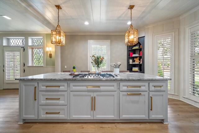 1111 Governors Dr, Corsicana, TX 75110 - kitchen featuring crown molding, stainless steel gas cooktop, white cabinets, light wood-type flooring, and light stone counters