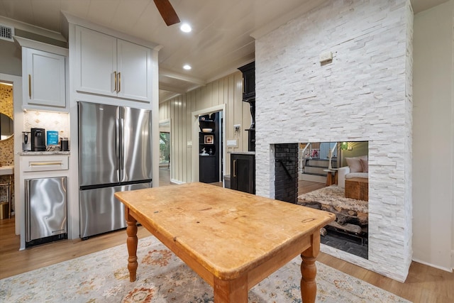 1111 Governors Dr, Corsicana, TX 75110 - kitchen with freestanding refrigerator, light wood-type flooring, a fireplace, recessed lighting, and backsplash
