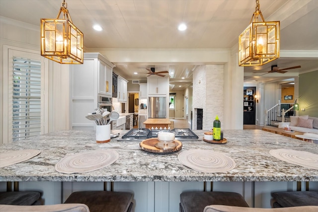 1111 Governors Dr, Corsicana, TX 75110 - kitchen featuring a ceiling fan, crown molding, stainless steel appliances, a breakfast bar, and recessed lighting