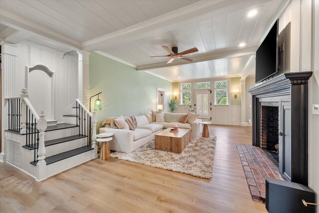 1111 Governors Dr, Corsicana, TX 75110 - living room with beam ceiling, light wood finished floors, a fireplace, ceiling fan, and crown molding