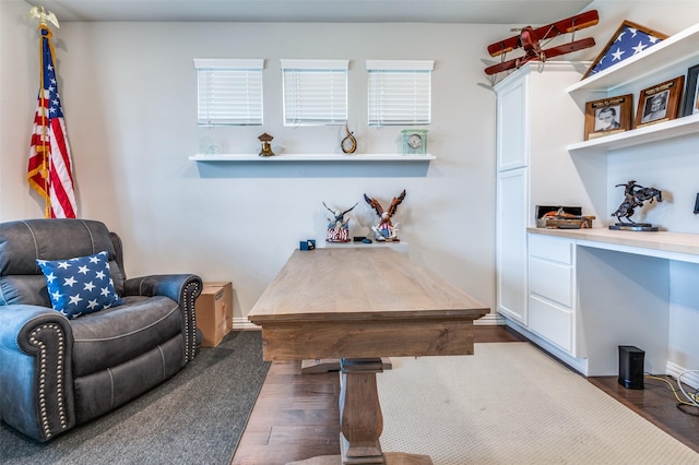 office area featuring wood finished floors, built in desk, and baseboards