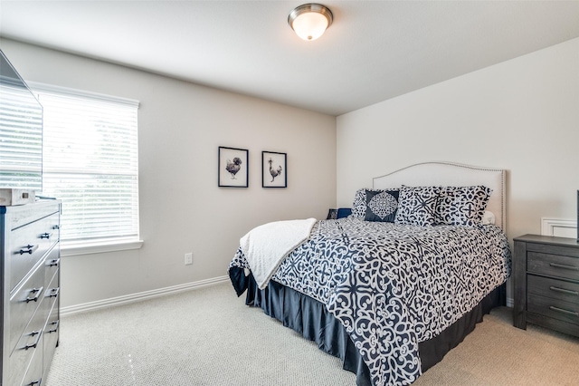bedroom with carpet floors, multiple windows, and baseboards
