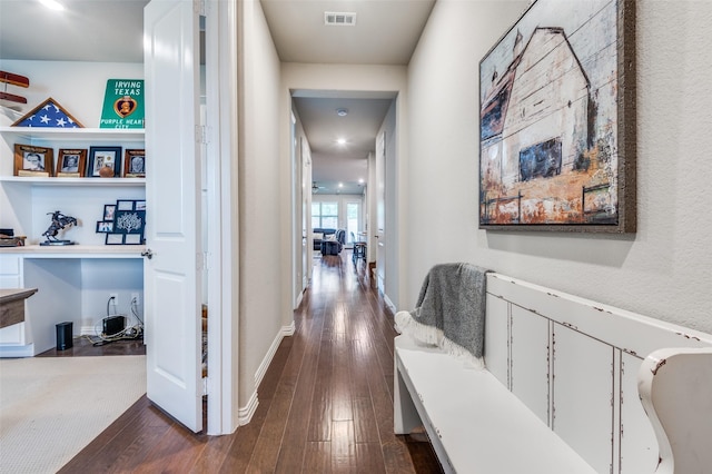 corridor with dark wood-style floors and baseboards