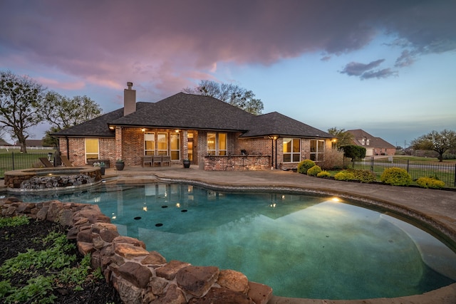11448 Brook Green Ln, Haslet, TX 76052 - pool at dusk featuring a fenced backyard, a patio area, and a pool with connected hot tub