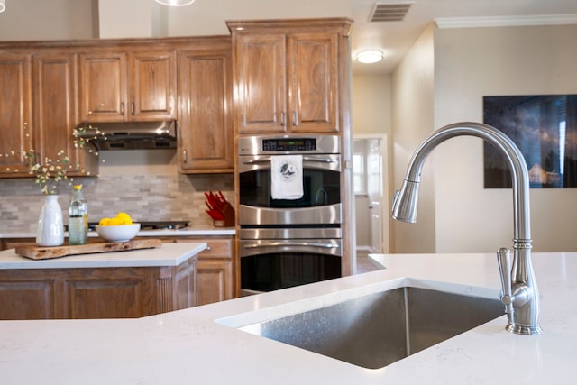 11448 Brook Green Ln, Haslet, TX 76052 - kitchen with double oven, exhaust hood, brown cabinets, and crown molding