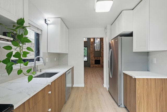 2755 Harbinger Ln, Dallas, TX 75287 - kitchen with a sink, light wood-type flooring, stainless steel appliances, light stone countertops, and white cabinets