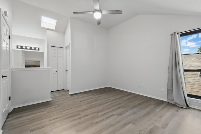 2755 Harbinger Ln, Dallas, TX 75287 - unfurnished bedroom with lofted ceiling, a skylight, wood finished floors, baseboards, and a ceiling fan