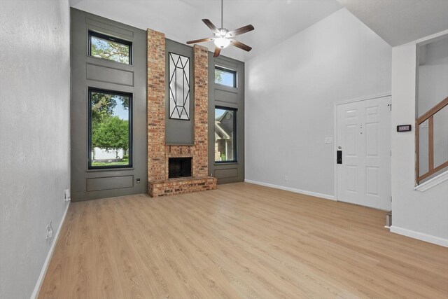 2755 Harbinger Ln, Dallas, TX 75287 - unfurnished living room featuring wood finished floors, baseboards, a ceiling fan, a towering ceiling, and stairway