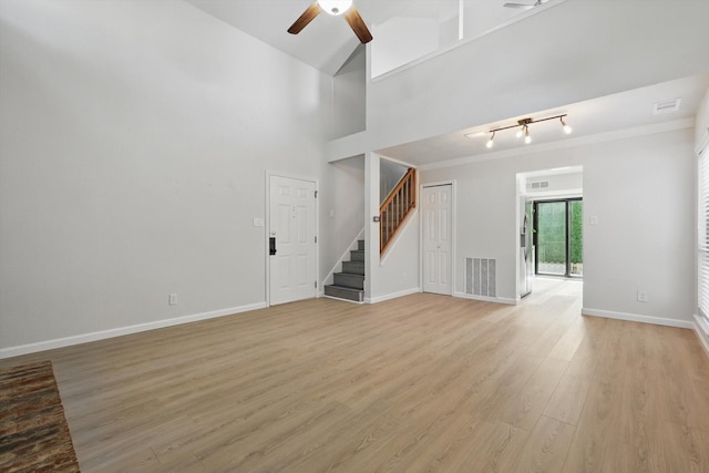2755 Harbinger Ln, Dallas, TX 75287 - unfurnished living room with a ceiling fan, stairs, light wood finished floors, baseboards, and rail lighting
