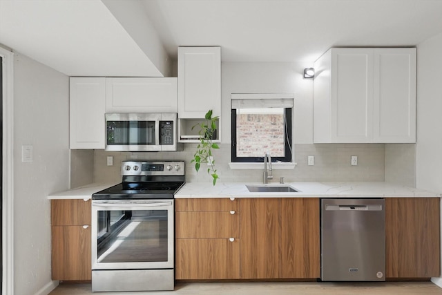 2755 Harbinger Ln, Dallas, TX 75287 - kitchen with stainless steel appliances, a sink, white cabinets, tasteful backsplash, and light stone countertops