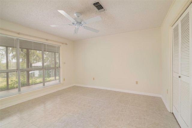 321 Evangeline Dr, Elm Grove, LA 71051 - unfurnished bedroom with a textured ceiling, light tile patterned floors, a closet, a ceiling fan, and baseboards