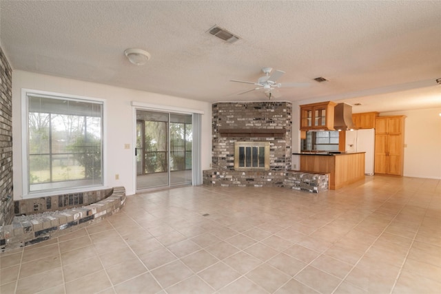 321 Evangeline Dr, Elm Grove, LA 71051 - unfurnished living room with a ceiling fan, light tile patterned floors, a textured ceiling, and a fireplace