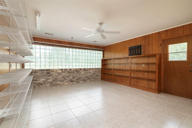 321 Evangeline Dr, Elm Grove, LA 71051 - tiled empty room with wood walls, ceiling fan, ornamental molding, and brick wall