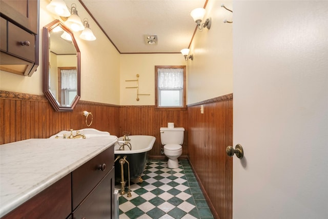 321 Evangeline Dr, Elm Grove, LA 71051 - bathroom featuring wainscoting, a freestanding bath, toilet, vanity, and tile patterned floors