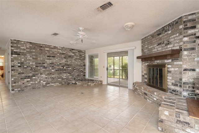 321 Evangeline Dr, Elm Grove, LA 71051 - unfurnished living room featuring ceiling fan, tile patterned floors, a textured ceiling, a fireplace, and brick wall