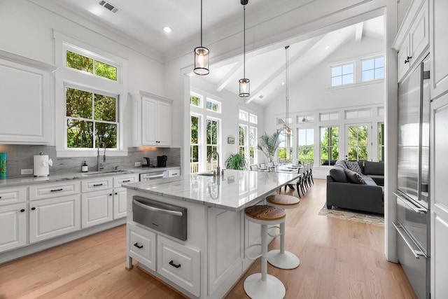 4525 E Cove Ct, Malakoff, TX 75148 - kitchen featuring a warming drawer, beamed ceiling, backsplash, light wood finished floors, and an island with sink