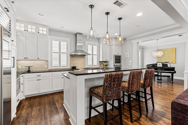 4144 Emerson Ave Unit 2, University Park, TX 75205 - kitchen featuring wall chimney range hood, backsplash, ornamental molding, dark countertops, and stainless steel appliances