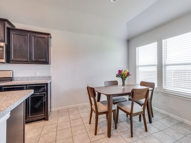 16757 Portage St, Justin, TX 76247 - dining space with vaulted ceiling, baseboards, and light tile patterned flooring