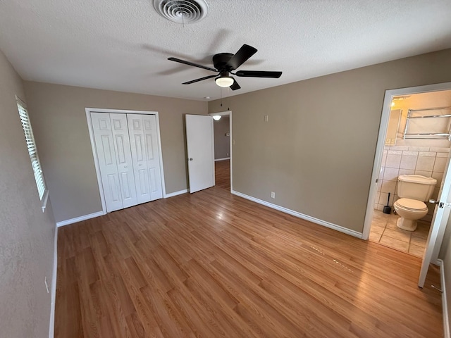 2325 S 40th St, Abilene, TX 79605 - unfurnished bedroom featuring light wood-type flooring, a textured ceiling, a closet, baseboards, and ensuite bathroom