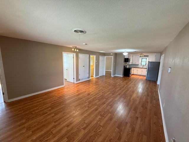 2325 S 40th St, Abilene, TX 79605 - unfurnished living room with dark wood finished floors, a textured ceiling, and baseboards