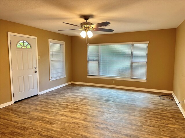 213 W Tennie St, Gainesville, TX 76240 - entryway with wood finished floors, a ceiling fan, baseboards, and a textured ceiling