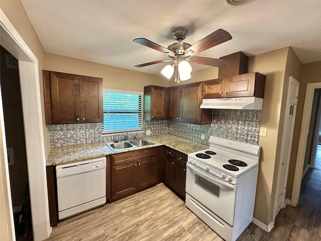 213 W Tennie St, Gainesville, TX 76240 - kitchen with white appliances, a sink, under cabinet range hood, light wood-type flooring, and decorative backsplash