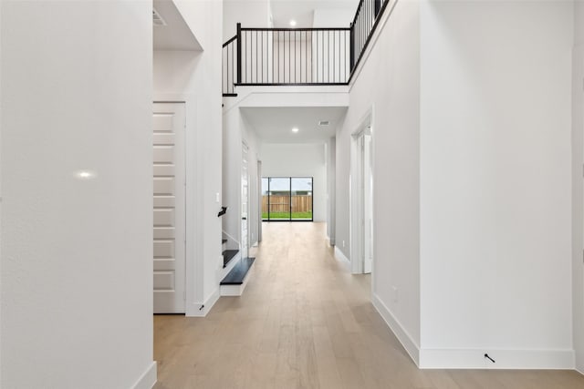 4160 Rosita Ln, Prosper, TX 75078 - hall with light wood-style flooring, baseboards, stairs, and a high ceiling