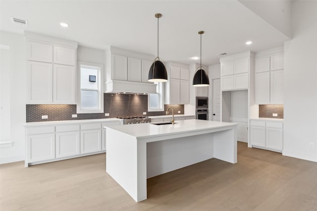 4160 Rosita Ln, Prosper, TX 75078 - kitchen featuring appliances with stainless steel finishes, tasteful backsplash, white cabinetry, a sink, and an island with sink