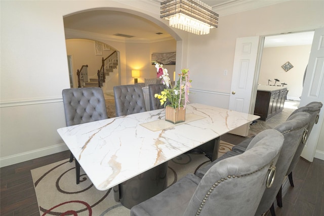 dining space featuring ornamental molding, arched walkways, stairs, baseboards, and dark wood-style flooring
