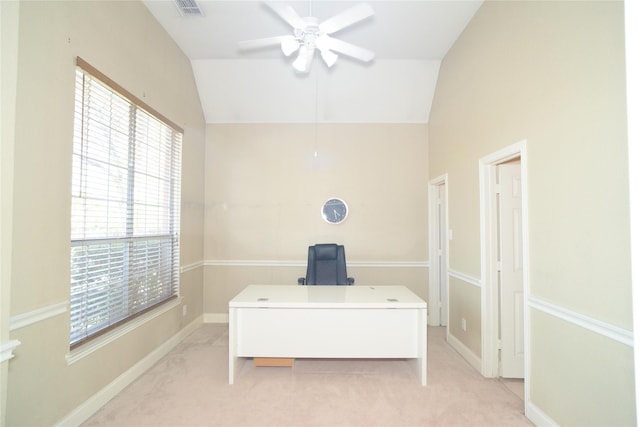 office area featuring ceiling fan, healthy amount of natural light, vaulted ceiling, and light carpet