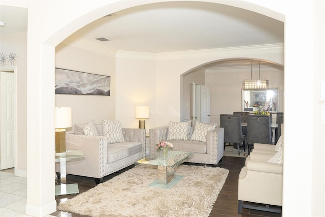 living room featuring ornamental molding, arched walkways, and wood finished floors